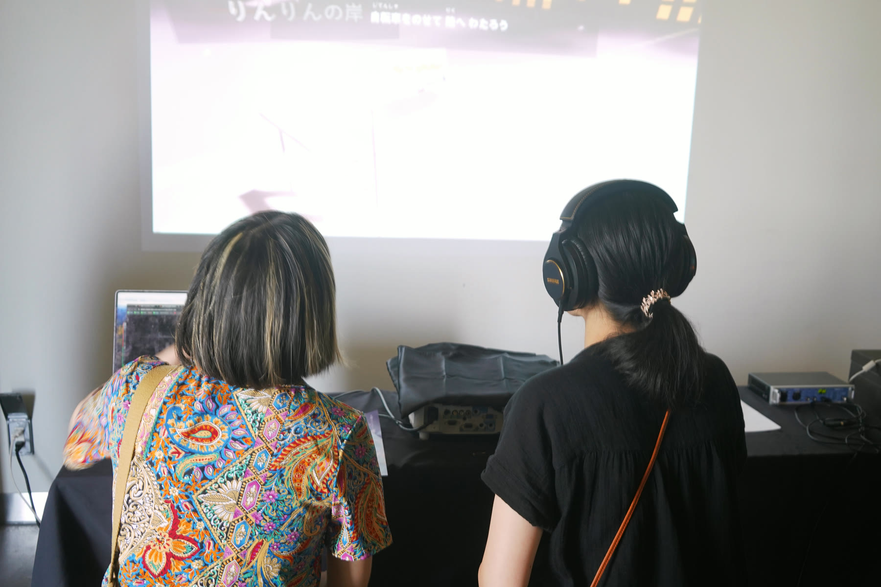 ヘッドフォンで音を聴くふたりの来場者